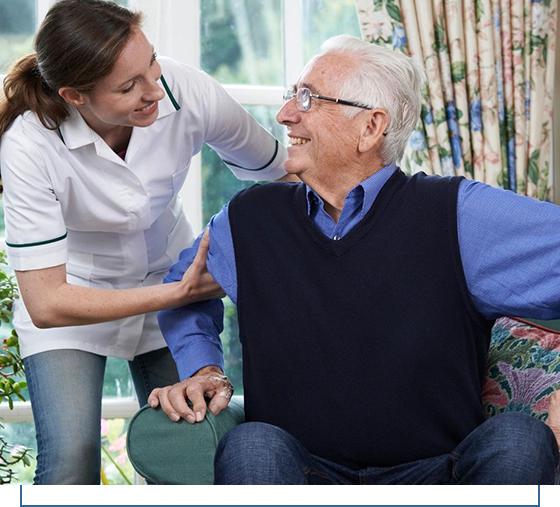 A woman helping an older man sit on the couch